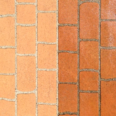Pavers part way through pressure cleaning, half grimy and half restored.
